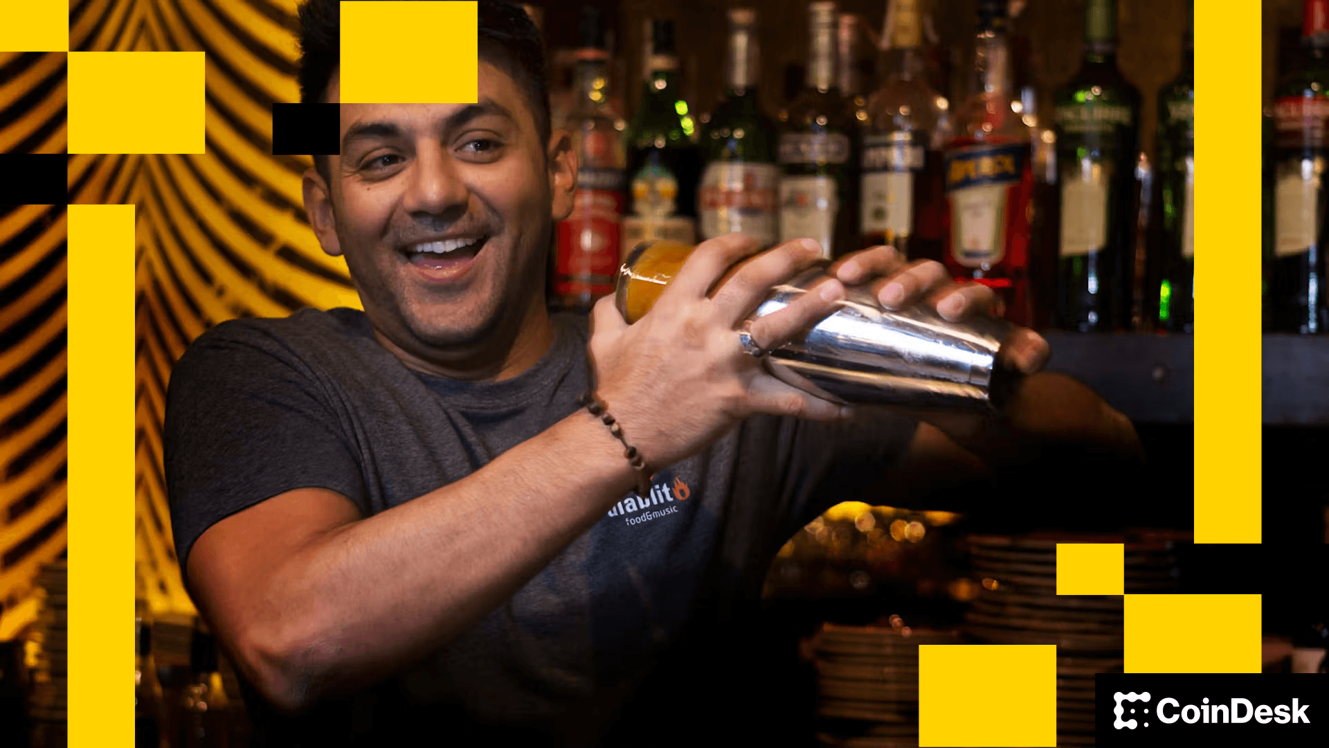 shaker, shaking, cocktail, mixologist A barman shakes a cocktail shaker with an array of drinks bottles behind him.
